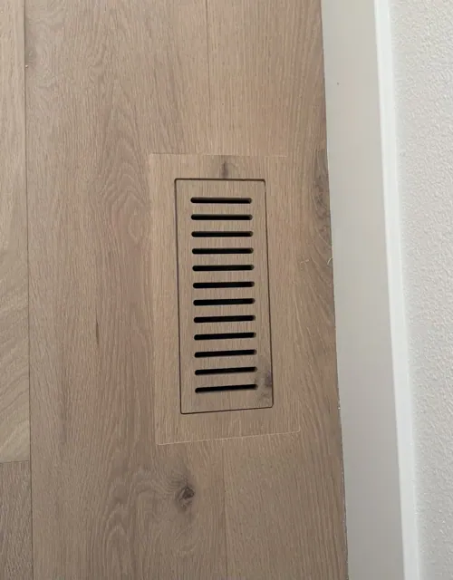 Custom CNC-milled wood floor vent flush with hardwood in a Seattle home