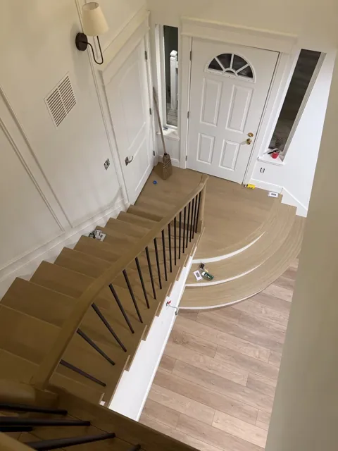 Remodeled curved oak staircase with black balusters in a Seattle home