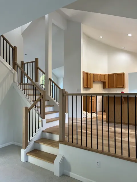 Wood and metal railing with oak handrail and black balusters in a Seattle home